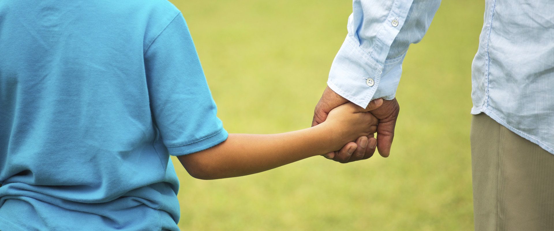 Image of child and adult holding hands.